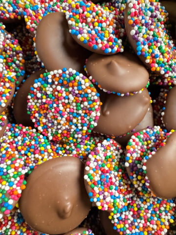 Tempered milk chocolate nonpareils with vibrant rainbow nonpareil sprinkles.