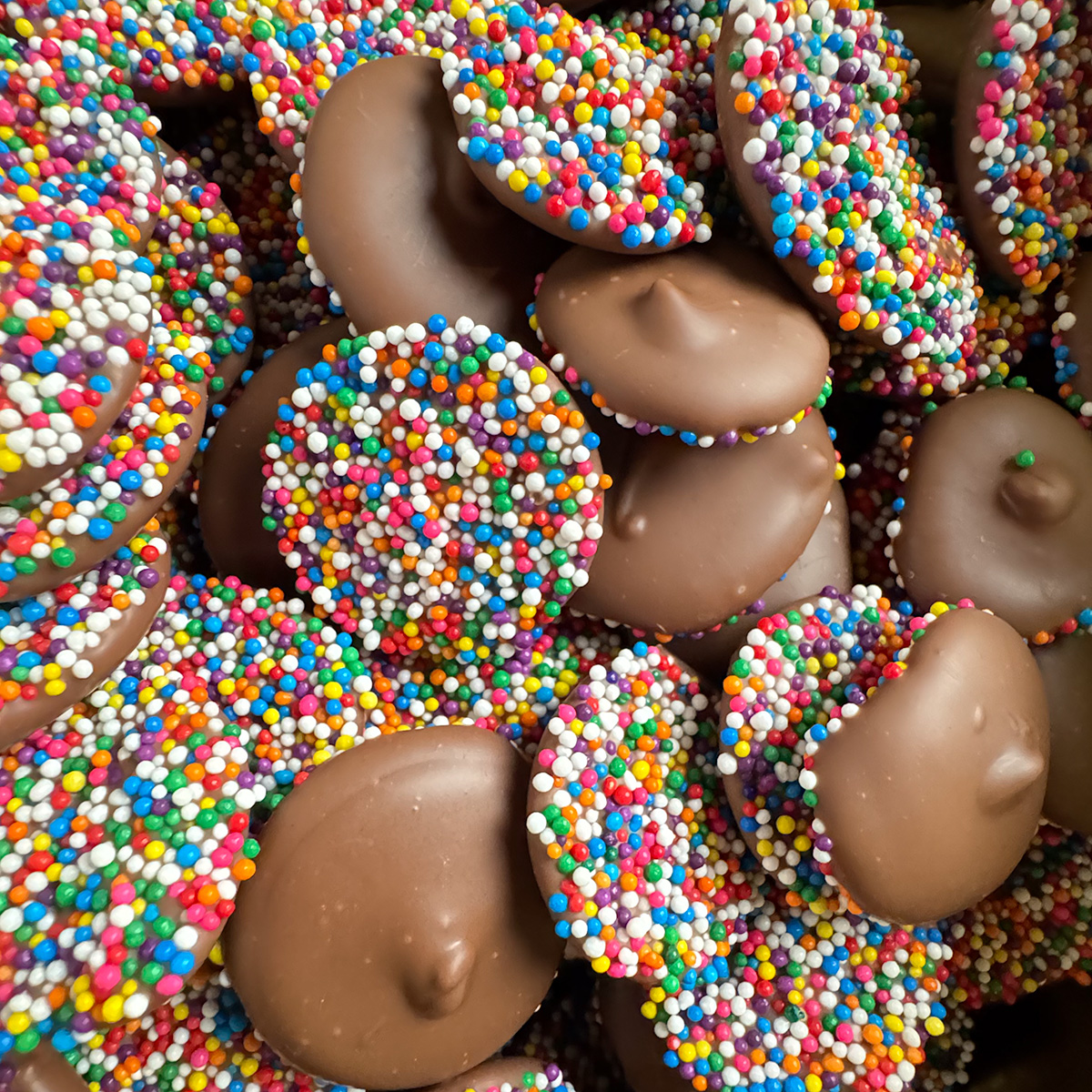 Tempered milk chocolate nonpareils with vibrant rainbow nonpareil sprinkles.