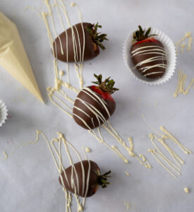 Four chocolate strawberries with fresh white chocolate drizzle.
