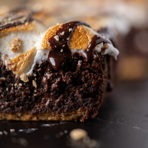 Homemade chocolate sauce dripping down the side of a s'mores brownie.