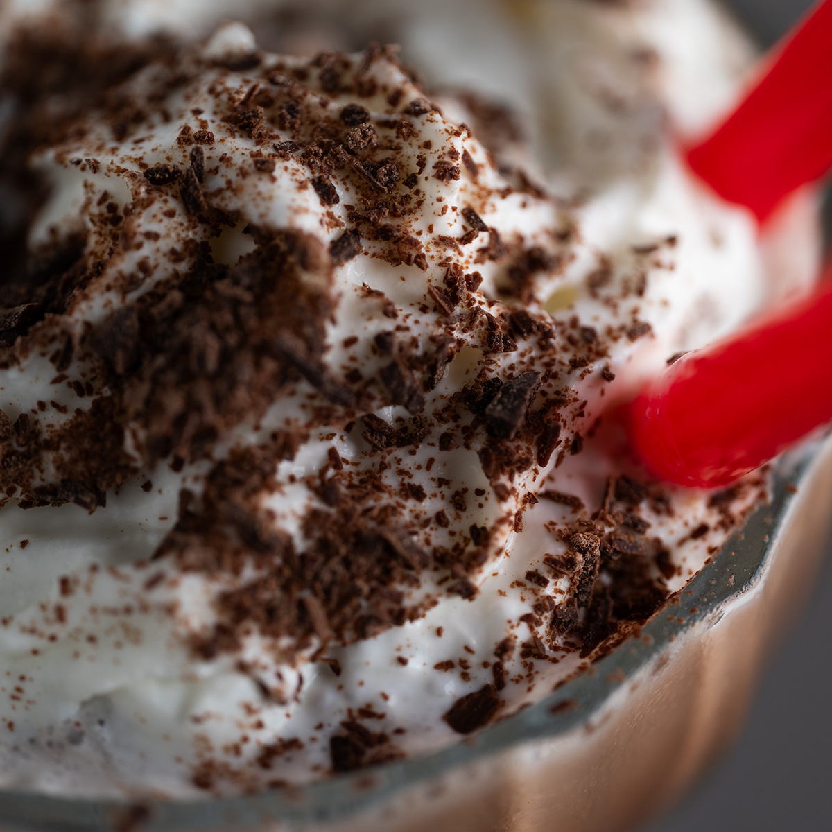 Macro of the chocolate shavings atop the whipped cream of a frozen hot chocolate.