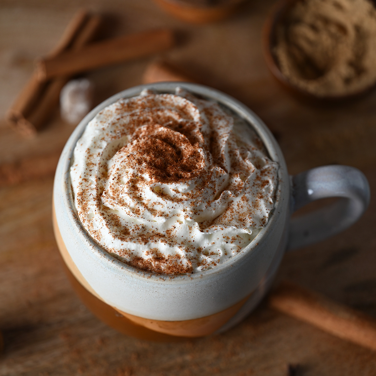 Homemade pumpkin spice blend sprinkled over a mug of pumpkin spice hot chocolate.